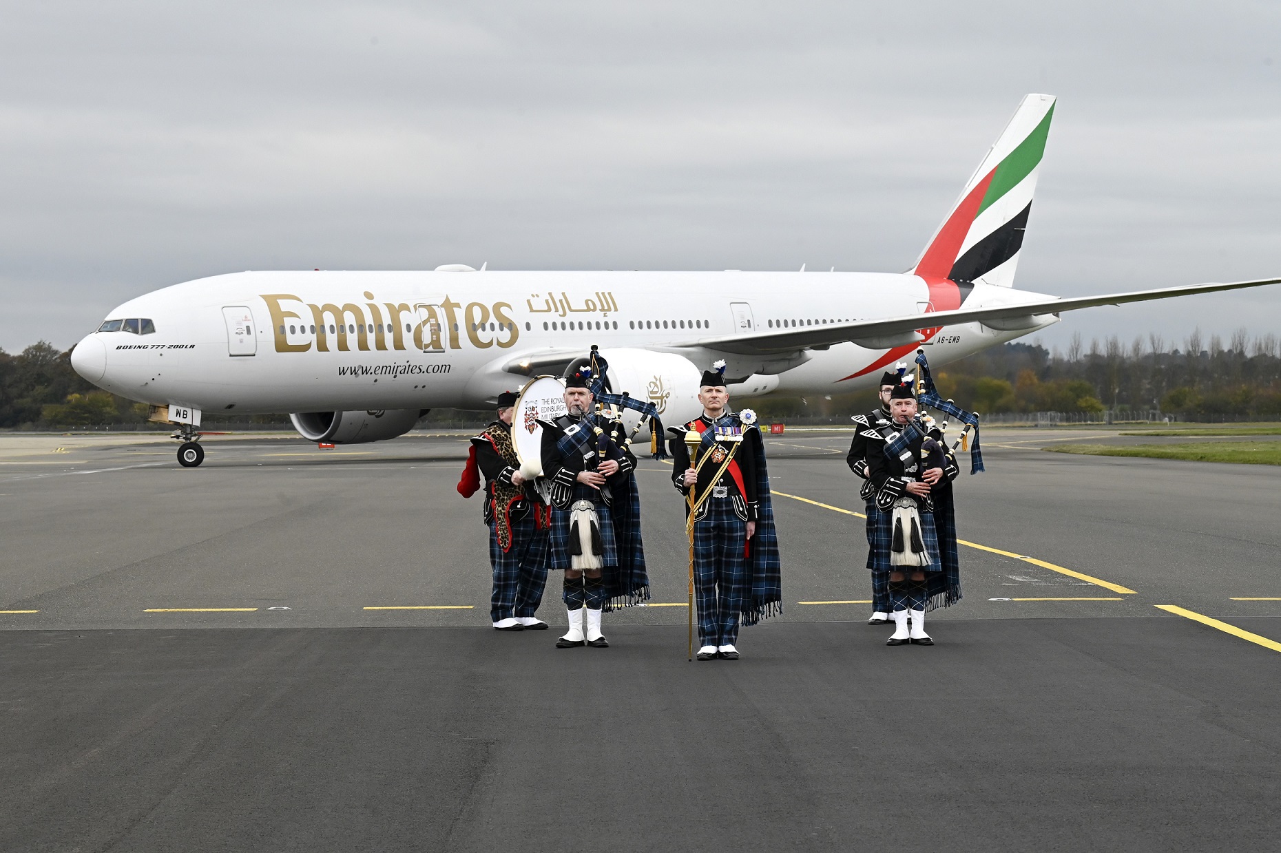 Bagpipers playing in front of the Emirates 777