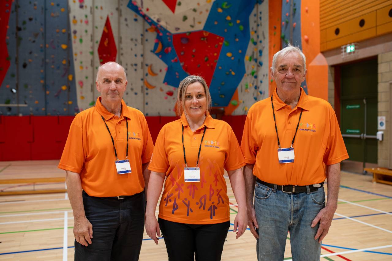 Three people in matching volunteer uniforms