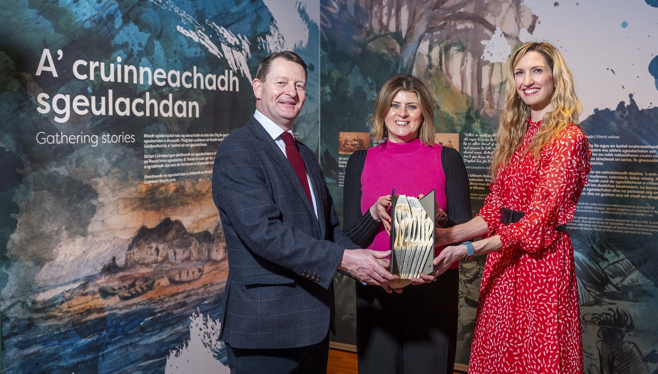 Three people standing all holding a book National Library of Scotland in Edinburgh. Credit – VisitScotland / Phil Wilkinson