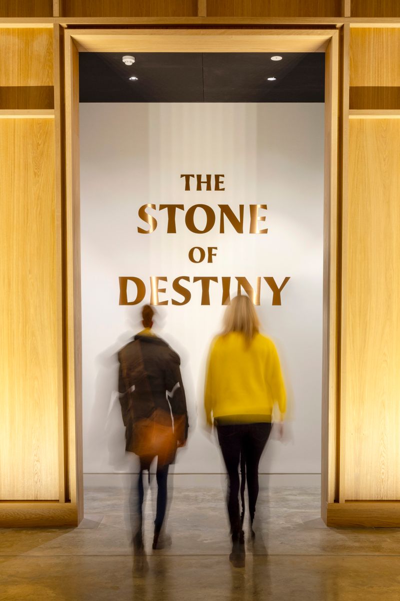 two people walking toward an entrance with reads "Stone of Destiny"